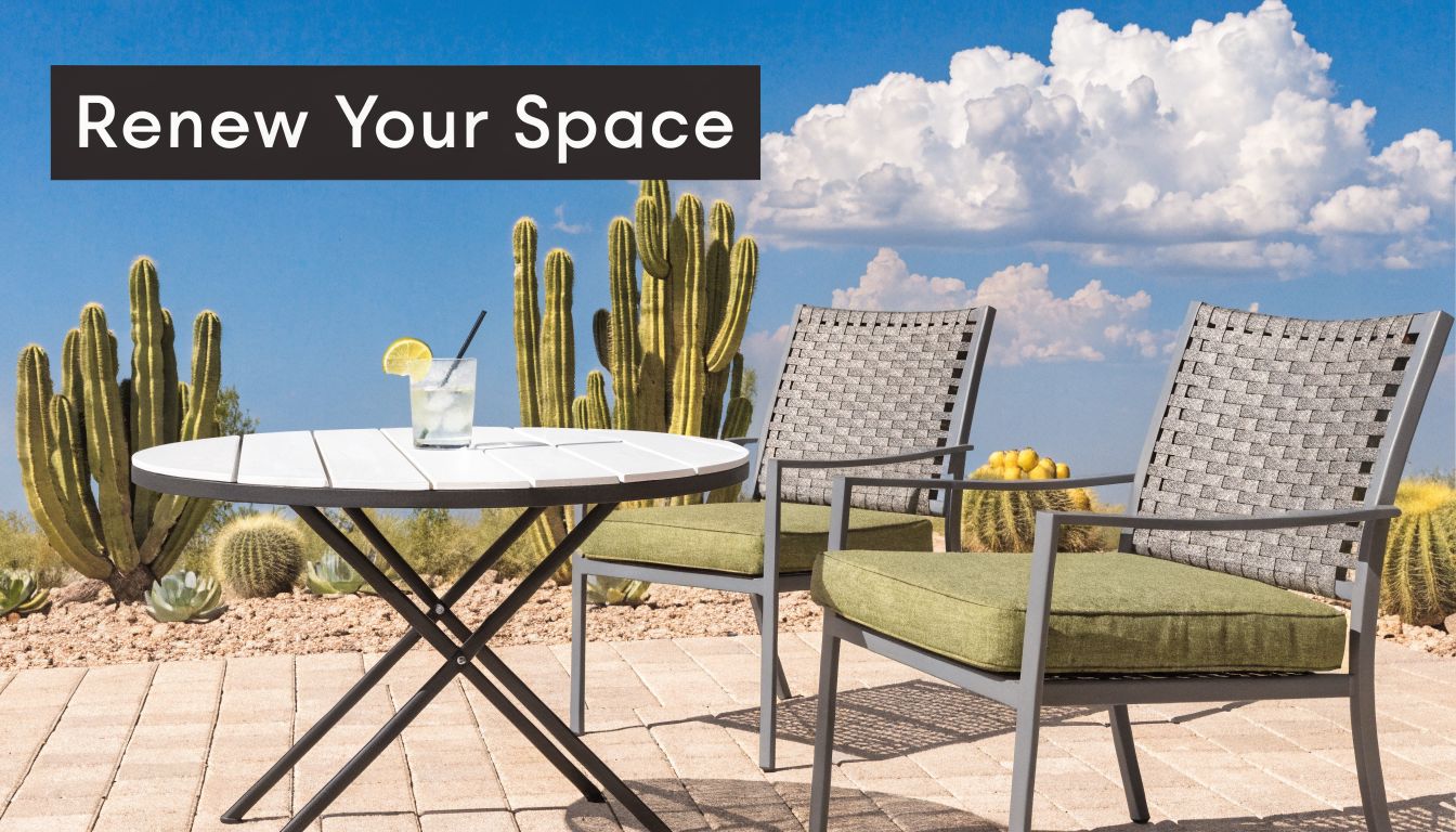 A modern outdoor patio set with chairs and a table placed in a sunny desert landscape.