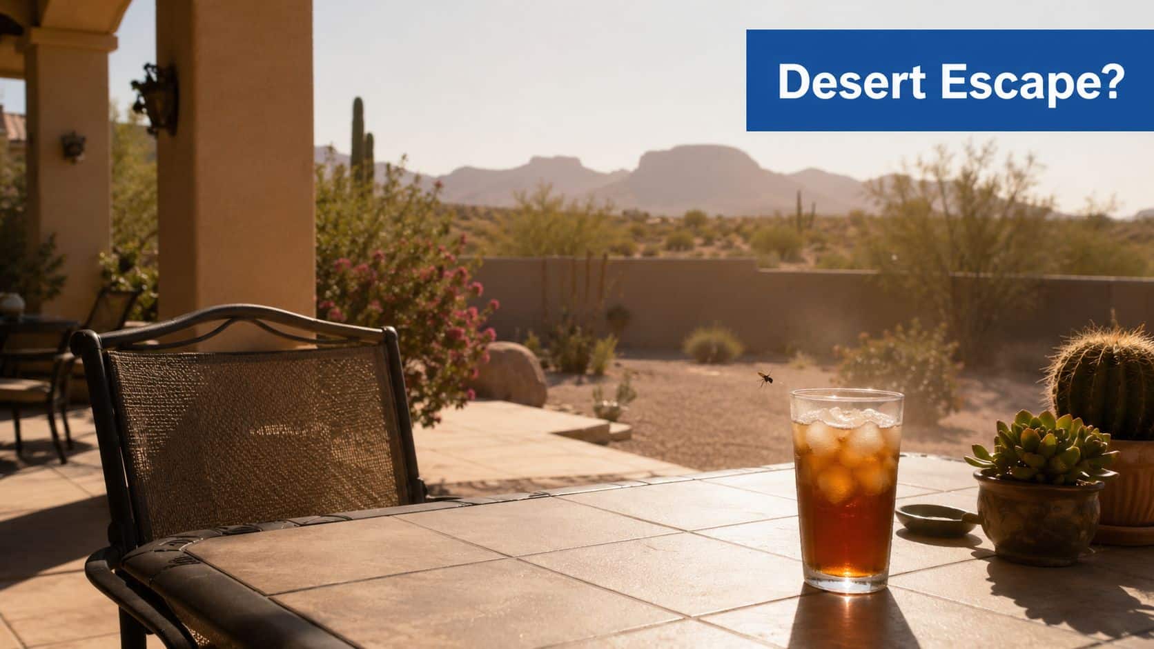A glass of iced tea on a patio table with desert mountains in the background