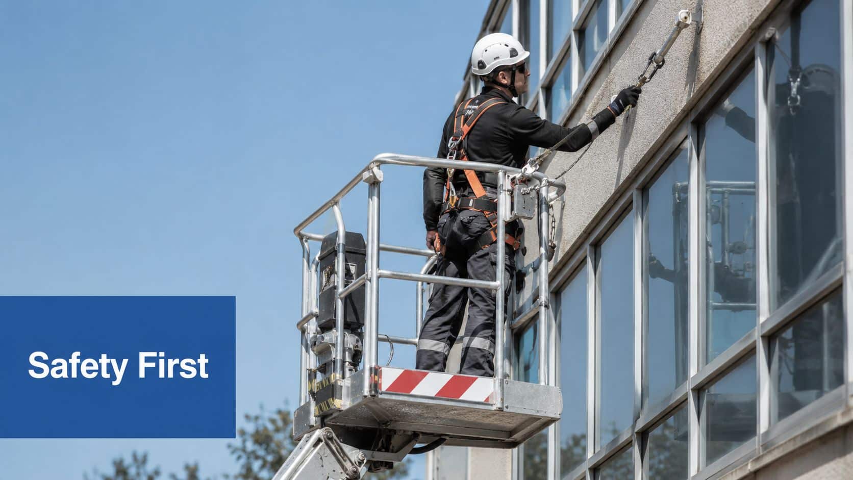 A professional construction worker wearing a safety harness and hard hat working on an elevated platform.