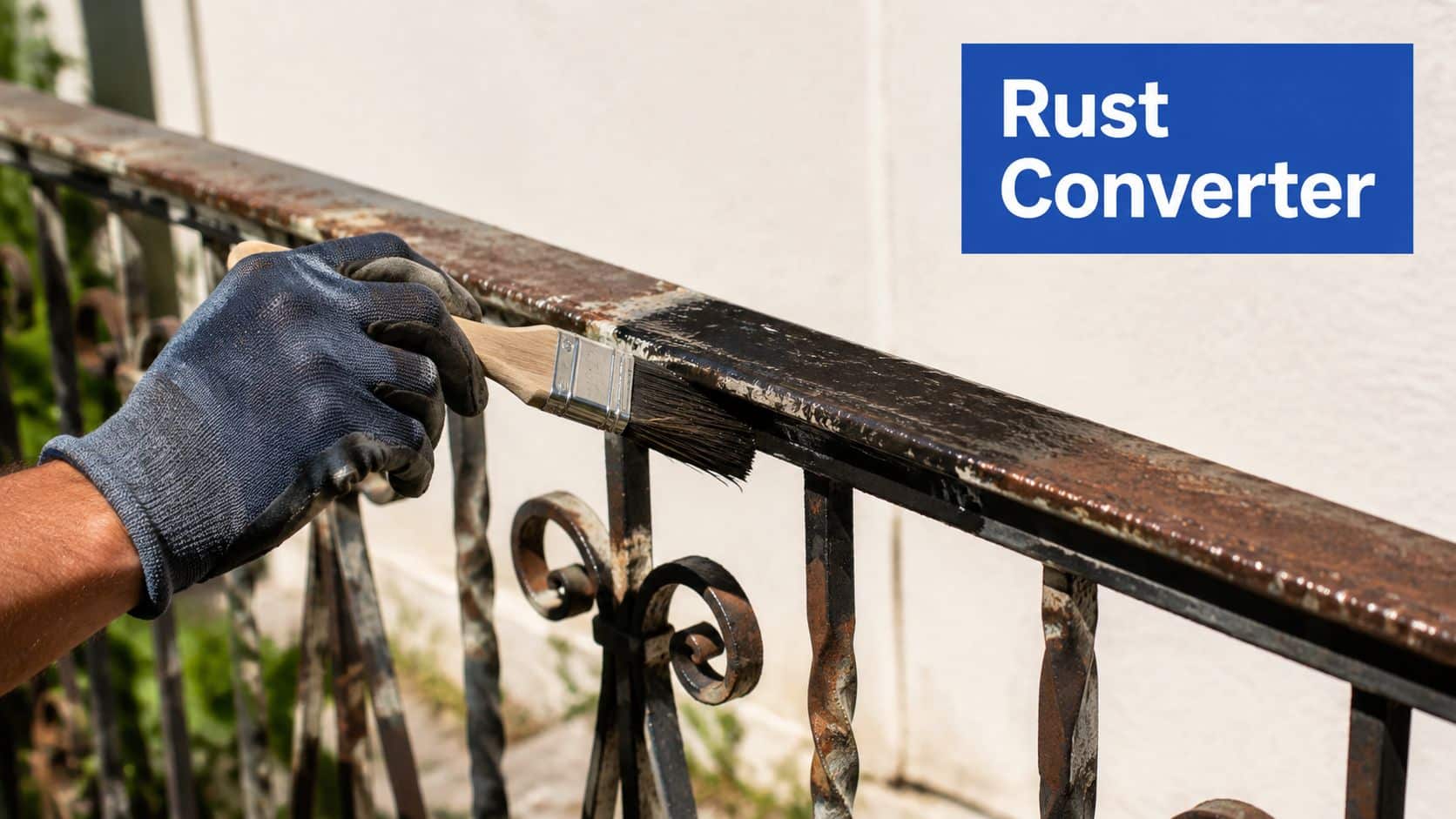 A person wearing a glove applies a rust converter to a metal railing with a brush.